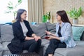 Two businesswomen talking and discussing in office, sitting on couch Royalty Free Stock Photo