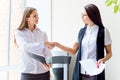 Two businesswomen telling gossip in an office