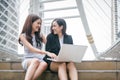 Two businesswomen working on laptop computer with happy funny em