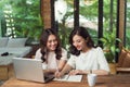 Two businesswomen working together. Girl is sitting at table in Royalty Free Stock Photo