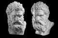 Two bust of Hercules. Heracles head sculpture, plaster copy of a statue isolated on black. Son of Zeus. Ancient statue Royalty Free Stock Photo