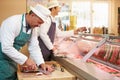 Two Butchers Preparing Meat In Shop Royalty Free Stock Photo