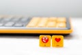 Two buttons with the image of an angry emoticon and a heart on the background of a blurred keyboard. The concept of social