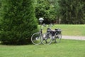 Two bycicles parked near bushes in park. Royalty Free Stock Photo