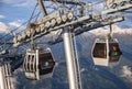 Two cableway ski lift cabins on mountain forest background close up view