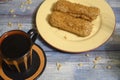 Two cakes on a plate and a mug of coffee on a wooden background Royalty Free Stock Photo