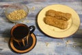 Two cakes on a plate, pine nuts and a mug of coffee on a wooden background Royalty Free Stock Photo