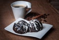 Two cakes on a white rectangular saucer glazed with black and white chocolate. Royalty Free Stock Photo