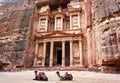 Two camels, saddles ready for tourists, sitting in front of Al-Khazneh Treasury temple - main attraction in Lost city of Royalty Free Stock Photo