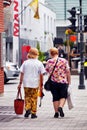 Two Canadian elderly women walking on the street with shopping bags in Montreal