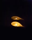 Two candles burning in the dark.One candle burns stronger, the second weaker. Royalty Free Stock Photo