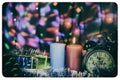 Two candles with clock and Christmas gifts with multi-colored lights on background old retro image Royalty Free Stock Photo