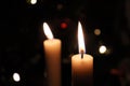 Two candles in front of a Christmas tree