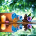 Two candles and towels black stones and purple daisy on water Royalty Free Stock Photo