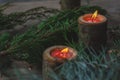 Two candles in wooden candlesticks.  Bright fire of orange candles-tablets. Festive decor for a wedding or Valentine`s Day. Royalty Free Stock Photo