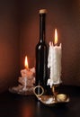 Two candlesticks and black bottle