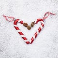 Two candy canes heart on snow background