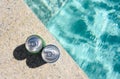 Two cans of cold drink by the pool on a hot summer day. Royalty Free Stock Photo