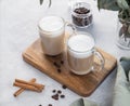 Two cappuccino or latte with milk foam in glasses on a light background with coffee beans, cinnamon and eucalyptus branch Royalty Free Stock Photo