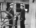 Two captains shaking hands on a boat