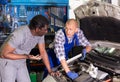 Two car mechanic diagnosing auto engine problem in service Royalty Free Stock Photo