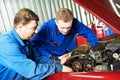 Two car mechanic diagnosing auto engine problem Royalty Free Stock Photo