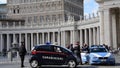 Two Carabinieri and a Policeman stand near the Colonnade of St. Peter Church in Vatican City