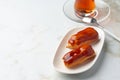 Two caramel eclairs on a white plate