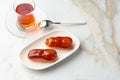 Two caramel eclairs on a white plate