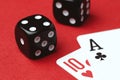 Two cards and black dice on a red background, close-up Royalty Free Stock Photo