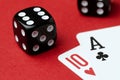 Two cards and black dice on a red background, close-up Royalty Free Stock Photo