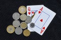 Two cards from the French deck showing a blackjack, accompanied by several Colombian coins. Royalty Free Stock Photo