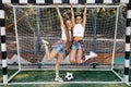 Two carefree young teenage hipster girls posing with happy faces in front of goal post at the soccer stadium. Freedom Royalty Free Stock Photo