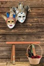 Two carnival masks hanging on the wall at the bottom of a wooden Royalty Free Stock Photo