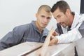 Two carpenters looking at wood piece Royalty Free Stock Photo
