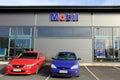 Two Cars in front of a Shop with Mobil Sign