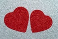 Two carved red hearts on a gray glossy background. Abstract shiny pattern. Craft paper, glitter, sparkling texture. Love concept Royalty Free Stock Photo