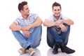 Two casual men sitting on a white background Royalty Free Stock Photo