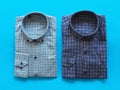 Two casual mens shirts on a blue background