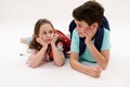 Happy smart school kids, a teen boy a little girl with backpacks talking together, isolated on white studio background