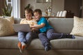 Two caucasian boys using laptop sitting on the couch at home Royalty Free Stock Photo