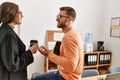 Two caucasian business executives talking and drinking coffee at the office Royalty Free Stock Photo