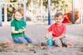 Two Caucasian children sitting in sandbox playing with beach toys. Little boys friends having fun together on a playground. Summer Royalty Free Stock Photo