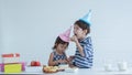 Two Caucasian kids little boy and girl enjoy eating birthday cake with hands at home on white background Royalty Free Stock Photo