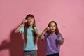 Two caucasian little girlfriends blow soap bubbles