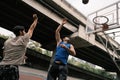 Two caucasian men pratice baskegball in court at urban street