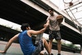 Two caucasian men pratice baskegball in court at urban street