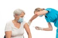 Two caucasian people - elderly pensioner lady and a nurse - the process of vaccination over white background. Copy space Royalty Free Stock Photo