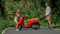 Love couple on red motorbike in white clothes, sunglasses on forest road trail trip. Dancing road. Two caucasian tourist Royalty Free Stock Photo