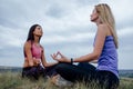 two caucasian woman, doing yoga asana, Young Female wearing sport clothes in lotus pose Royalty Free Stock Photo